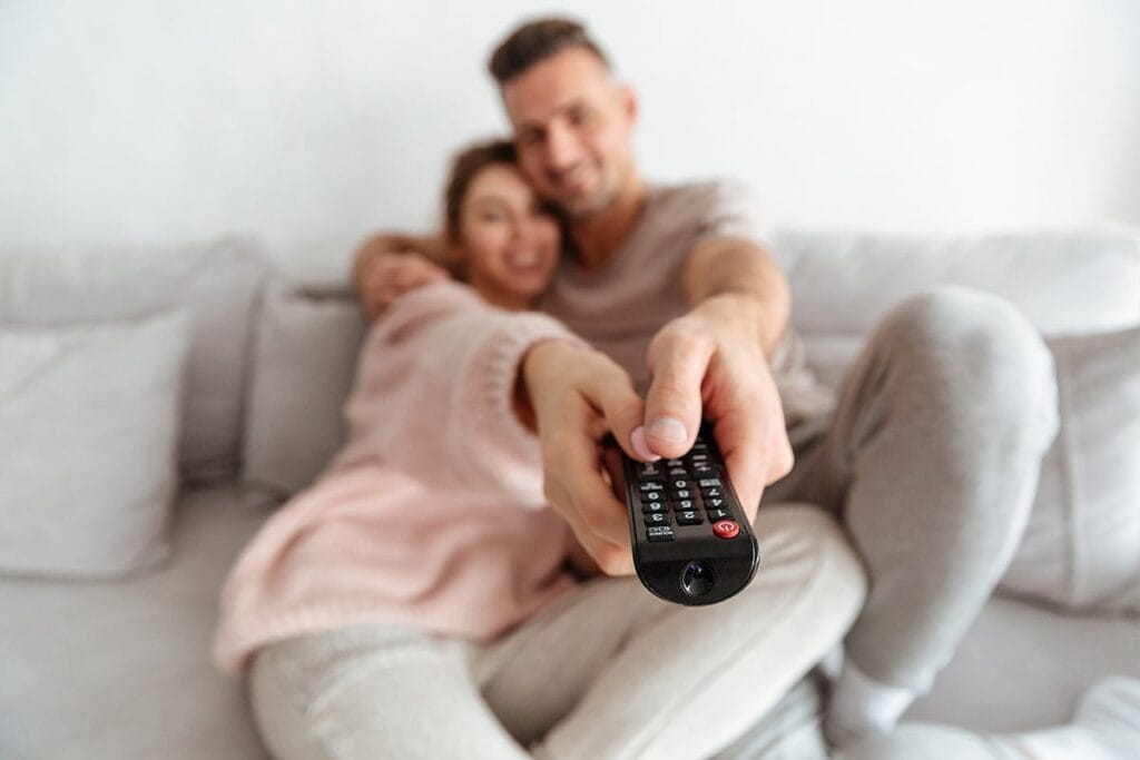 Pareja sosteniendo mando a distancia de TV