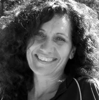 Retrato en blanco y negro de una mujer sonriente con cabello rizado oscuro.