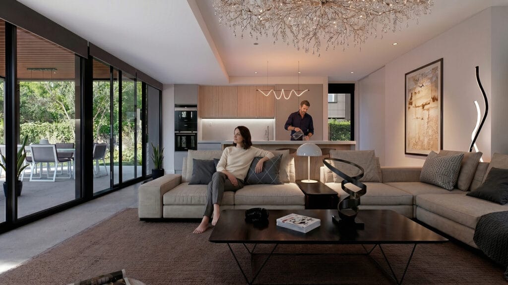 Salón contemporáneo del proyecto FUENTES CLARAS, con sofá modular gris, mesa de centro negra, cocina abierta al fondo y grandes ventanales hacia el jardín — render creado por GAYARRE